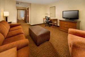 a hotel room with a couch and a flat screen tv at Drury Inn & Suites Valdosta in Valdosta