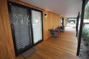 un porche cubierto con mesa y sillas en BIG4 Yarra Valley Park Lane Holiday Park, en Healesville