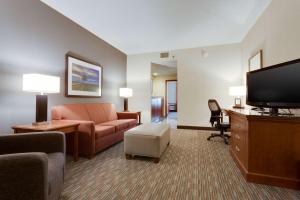 a living room with a couch and a flat screen tv at Drury Inn & Suites St. Louis/O'Fallon, IL in O'Fallon