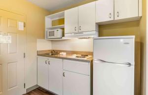 a kitchen with white cabinets and a white refrigerator at Extended Stay America Suites - Chesapeake - Churchland Blvd in Chesapeake