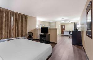 a hotel room with a bed and a flat screen tv at Extended Stay America Suites - Chesapeake - Greenbrier Circle in Chesapeake
