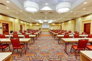 a conference room with tables and chairs and a projector at Drury Inn & Suites West Des Moines in West Des Moines
