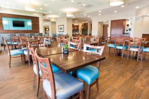 uma sala de jantar com mesas e cadeiras de madeira em Drury Inn & Suites Colorado Springs Near the Air Force Academy em Colorado Springs