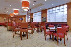 Drury Inn & Suites Baton Rouge في باتون روج: غرفة طعام مع طاولات وكراسي في مطعم