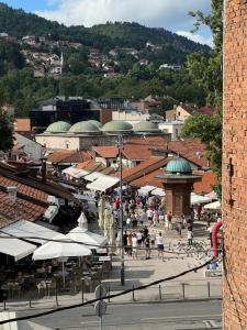 a crowd of people walking around a market with umbrellas at Guesthouse Yildiz in Sarajevo