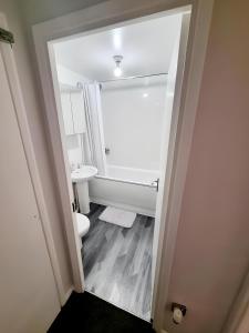 a bathroom with a toilet and a sink at Sleek & Stylish - E15 Apartment With Parking in London