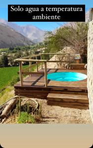 a wooden deck with a swimming pool in a yard at Ladera Loft Pisco Elqui in Pisco Elqui