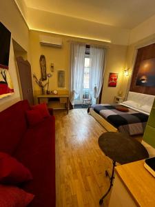 ナポリにあるCorso 211 Beds & Suitesのベッド2台とソファが備わるホテルルームです。
