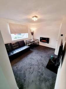 a living room with a couch and a table at Sleek & Stylish - E15 Apartment With Parking in London