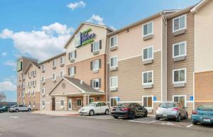 um hotel com carros estacionados num parque de estacionamento em Extended Stay America Select Suites - Kansas City - Stadium em Independence