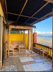 a porch with benches and a view of the beach at Koa's Beach House in Tangalan +14 photos