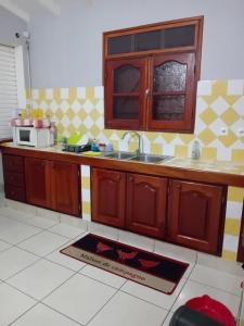 a kitchen with a sink and a microwave on the floor at Villa le vent du nord in Capesterre