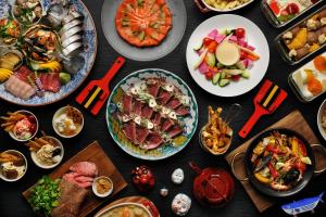 una mesa llena de platos de comida con diferentes alimentos en OMO7 Kochi by Hoshino Resorts en Kochi