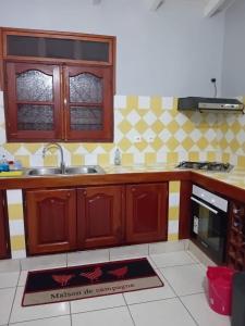 a kitchen with wooden cabinets and a sink at Villa le vent du nord in Capesterre
