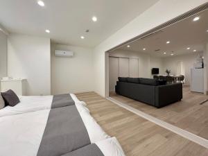 ein Schlafzimmer mit einem großen Bett und ein Wohnzimmer in der Unterkunft bHOTEL Nikke - Spacious Apt for 12Ppl Very Good Location in Ōsukachō