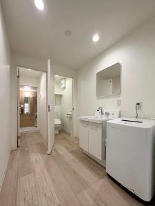 ein weißes Bad mit einem Waschbecken und einem WC in der Unterkunft bHOTEL Nikke - Spacious Apt for 12Ppl Very Good Location in Ōsukachō