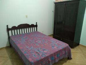 1 dormitorio con cama y tocador de madera en Casa agradável en Indaial