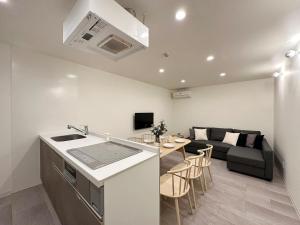 a kitchen and living room with a couch and a table at bHOTEL Nikke - Apt for 10Ppl Ideal for Big Group in City Center in Ōsukachō