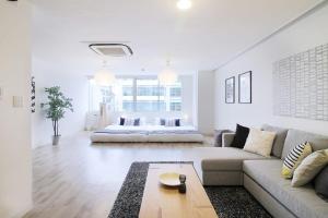 廣島的住宿－bHOTEL Nikke - 2BR Apt for 10ppl near Hondori Shopping，客厅配有沙发和床。