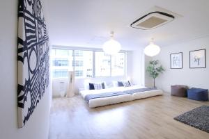a white living room with a large bed in it at b hotel Nikke - 2BR Apt for 10ppl near Hondori Shopping in Hiroshima
