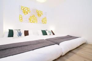 a bedroom with a large bed with white sheets at b hotel Nikke - 2BR Apt for 10ppl near Hondori Shopping in Hiroshima +33 photos