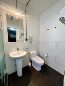 uma casa de banho com um lavatório, um WC e um espelho. em Hotel Bellavista Santiago Suite em Santiago