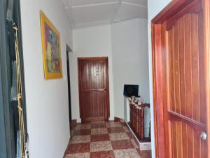 a hallway with a wooden door and a tile floor at Hostal Casa Yare in Rodadero
