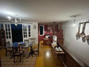Casa Temporada recanto de minas في تيرادينتيس: غرفة طعام وغرفة معيشة مع طاولة وكراسي