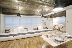 duża biała kanapa w pokoju ze stołem w obiekcie bHOTEL Nikke - 1BR Apt for 10ppl near Hondori Shopping w mieście Hiroszima