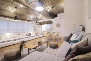 uma sala de estar com um sofá e uma mesa em bHOTEL Nikke - 1BR Apt for 10ppl near Hondori Shopping em Hiroshima