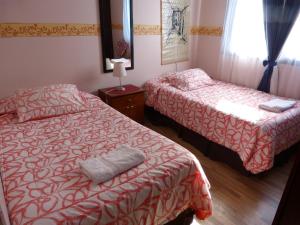 Habitación de hotel con 2 camas y espejo en Hostal Residencia Blest Gana, en Viña del Mar