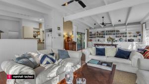 un salon avec deux canapés et une table dans l'établissement Bermagui Jewel on the Lake Cuttagee Bermagui Wifi provided, à Bermagui