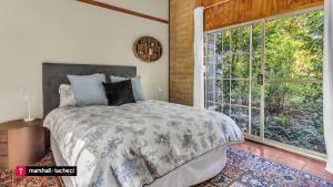 une chambre avec un lit et une grande fenêtre dans l'établissement Bermagui Jewel on the Lake Cuttagee Bermagui Wifi provided, à Bermagui