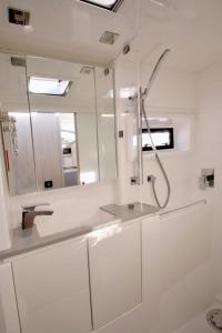 a white bathroom with a sink and a mirror at Florida Sail - Custom Sail Experiences in St Pete Beach