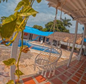 a swing in front of a swimming pool at Cabaña cerca a la playa, con piscina, en playa Mendoza atlántico. in Puerto Colombia