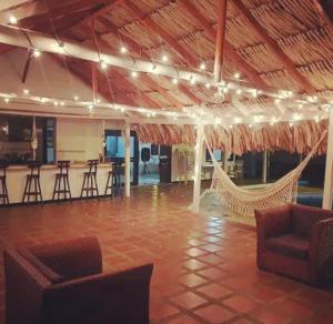 a large room with a hammock and a bar at Cabaña cerca a la playa, con piscina, en playa Mendoza atlántico. in Puerto Colombia