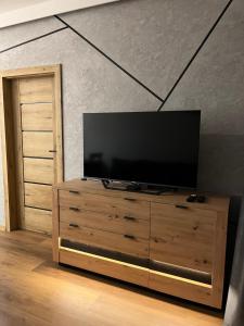 a television on a wooden dresser in a living room at Stare Miasto Elbląg Bulvar in Elblag