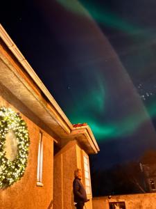 a person walking past a building with a rainbow in the sky at Casa Dísa - Dreams, A Boutique Guesthouse in Reykjavik City`s Central Park and Botanical Garden in Laugardalur, Hot-Spring-Valley in Reykjavík