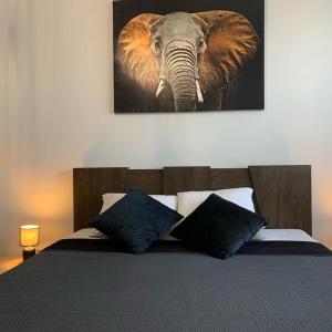 een slaapkamer met een bed met een olifantenverf aan de muur bij Central Park Apartment in Łódź