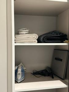 two shelves of a closet with towels and a fan at Al majdiah village قرية الماجدية in Riyadh