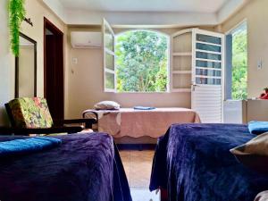 um quarto com duas camas e uma janela em Pousada JP em Vila Nova do Sul