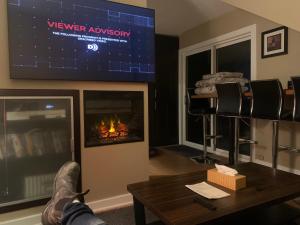 sala de estar con chimenea y TV en Where eagles fly en West Vancouver