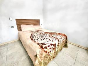 a bed in a room with a leopard blanket on it at El refugio de los viajeros in Quito