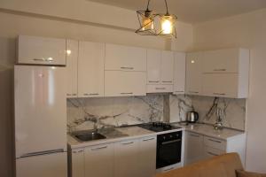 a white kitchen with white cabinets and a sink at CITY CENTER 2 in Shkodër