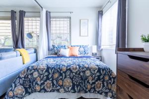 a bedroom with a blue bed and windows at King Bed + Studio! Free Parking, Patio, WFH Space! in Seattle