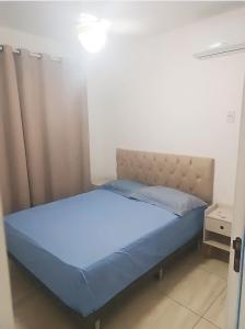 una camera da letto con un letto con un copriletto blu di Casa de Veraneio em Monte Gordo Guarajuba a Camassari Altre 18 foto