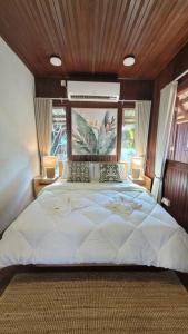 a bedroom with a large white bed with a wooden ceiling at Rumah Aggrek@Zaki’s Residence, Marang, Terengganu in Kampong Ru Lima