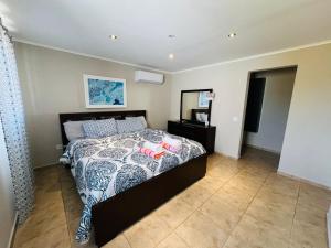 1 dormitorio con 1 cama con edredón blanco y negro en The Gold Vacation Villa en Santa Cruz
