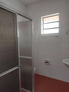 y baño con ducha y lavamanos. en Cabana em São Lourenço do Sul, en São Lourenço do Sul