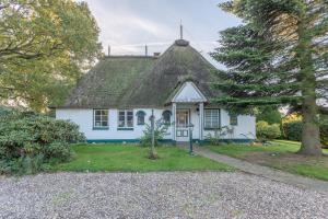 a small white house with a thatched roof at Kastanienhof Strandhafer in Wisch